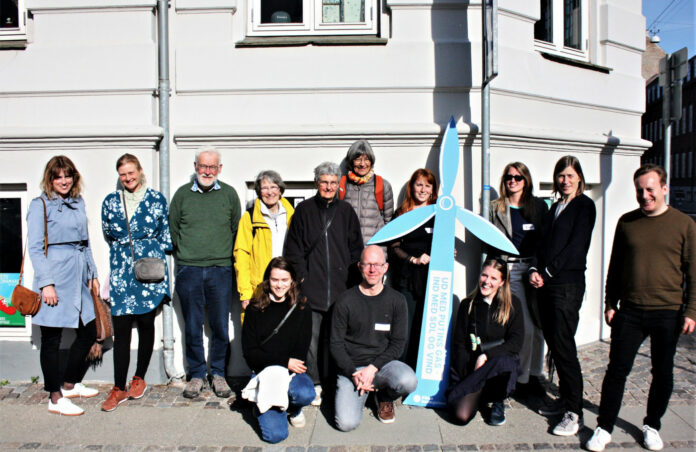 Aktivister fra Klimabevægelsen i Danmark står med en papvindmølle med teskten 
